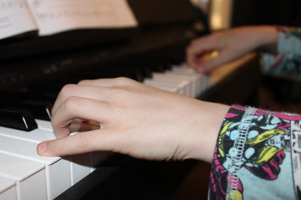 Hands of a young learner on the piano